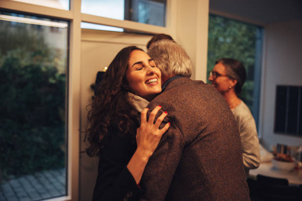 Family coming over at grandparents for Christmas dinner Grandparents greeting and welcoming visiting family at front door. Family coming over for Christmas dinner at the grandparents home. breaking the ice stock pictures, royalty-free photos & images