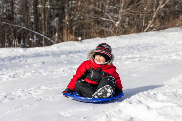 istock Little Boy Sledding on the Snow Outdoors in Winter 1343399222