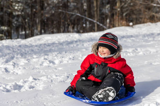 istock Little Boy Sledding on the Snow Outdoors in Winter 1343399847