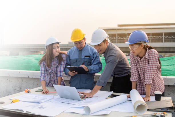 istock group of engineers is having a meeting about construction progress on site. 1343400853