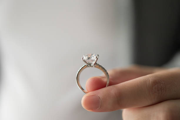 tenere a mano bellissimi gioielli anello di diamanti - ring gold diamond engagement ring foto e immagini stock