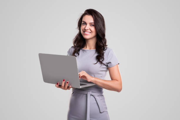 smiling businesswoman with laptop looking at camera - business women computer cheerful imagens e fotografias de stock