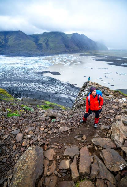 two women smiling at the top of mountain with vatnajokull glacier in background, iceland - skaftafell national park 個照片及圖片檔