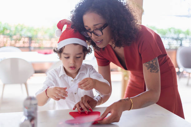 istock Loving mother helping son with Christmas art project 1343405078