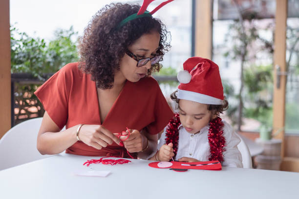 istock Loving mom helps son with Christmas art project 1343405089