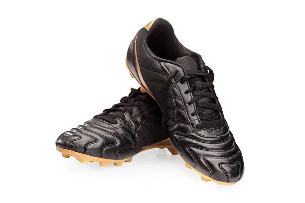 Pair of black leather soccer shoes isolated on white background