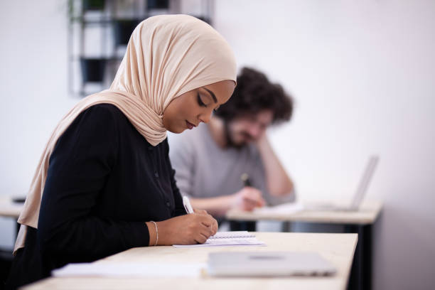 istock Multi ethnic students listening to a lecturer in a classroom. Smart young people study at a college. 1343407898