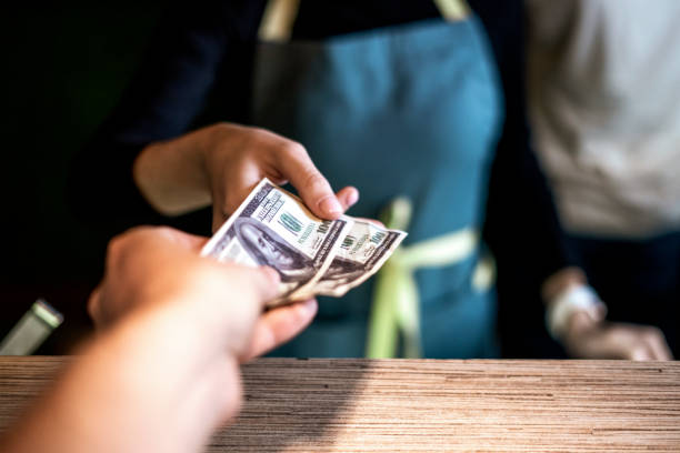 paying dollar cash to the waiter in cafe stock photo