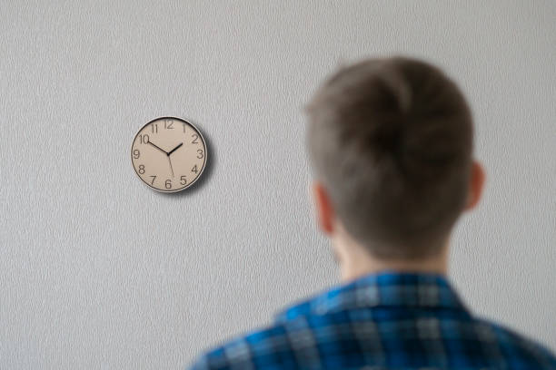 istock the worker in office checking time watching on the clock on wall, view frim behind, deadline problem 1343423253
