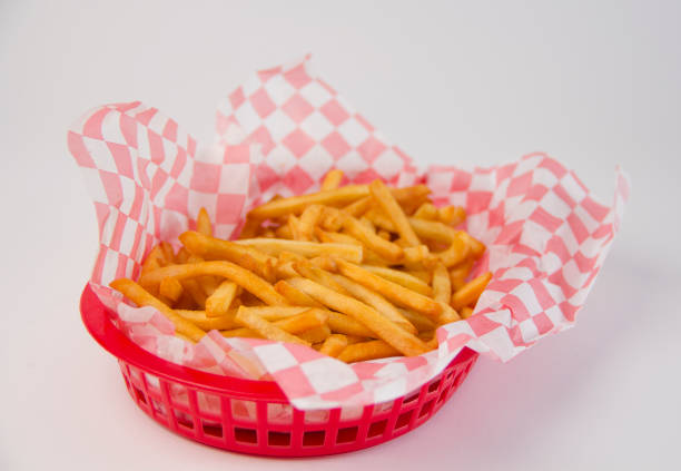 Tasty franchise french fries inside a basket with checkered papper pattern