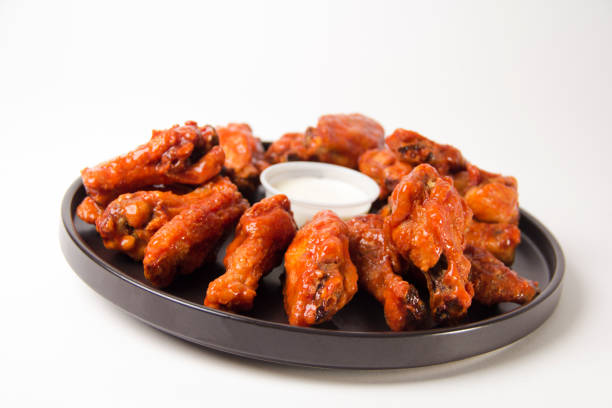 hot and spicy buffalo chicken wings close up on a white background - chicken wing white meat unhealthy eating plate imagens e fotografias de stock