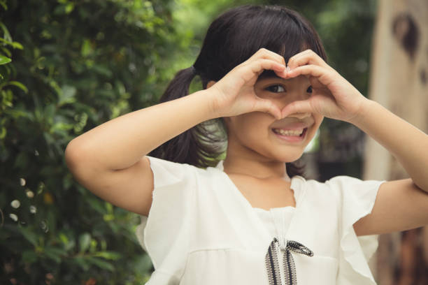istock Little girl hands making a heart shape on white background 1343446022
