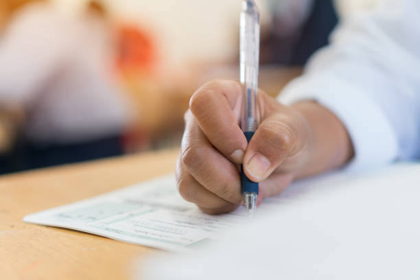 istock Writing test in exam Asian students concentrate in high school, serious taking final examination desk at classroom with Thai student uniform. Back to school for evaluation after COVID-19 pandemic 1343453123
