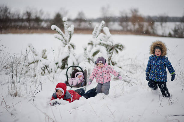 vier kinder, die spaß am wintertag haben. - 12 18 months stock-fotos und bilder