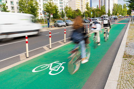 Group of bike riders commuting on a bicycle lane in the city.