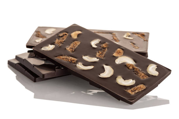 dunkle rohschokolade mit cashewnüssen und getrockneter feige auf weißem grund. - dried fig brown color image dried food stock-fotos und bilder