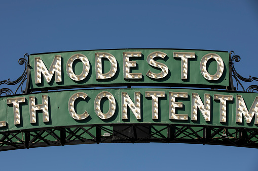 Modesto, California, USA - July 15, 2021: Daytime view of the historic 1912 Modesto Arch as it spans over I Street through downtown Modesto.