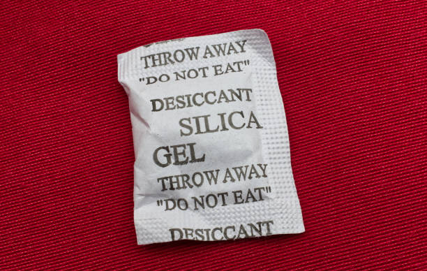istock Desiccant silica gel on red background. Synthetic substance absorbing moisture 1343464816