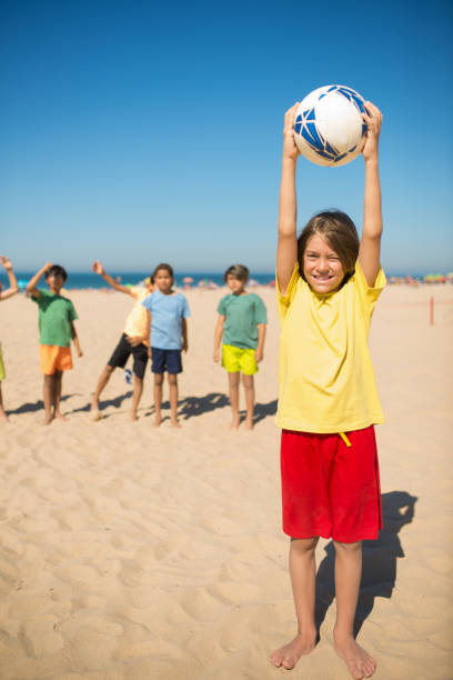 istock Happy preteen boy posing with ball over head 1343467997