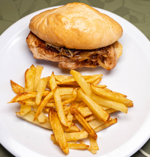 istock Plate with a pork and onion sandwich with fries 1343468265