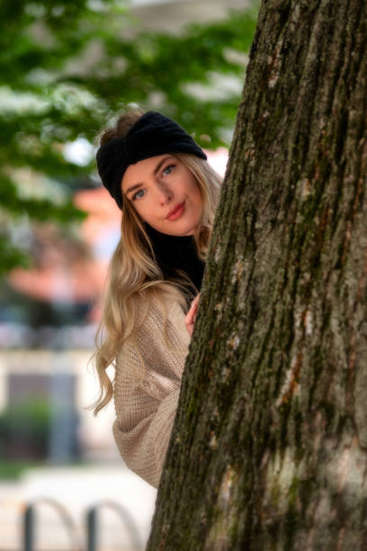 istock Pretty face young girl looking from behind a tree 1343468683