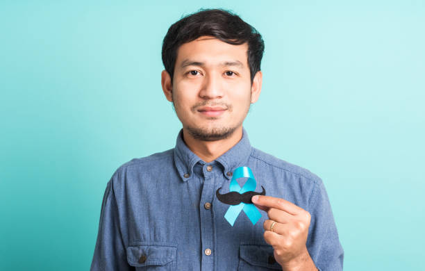 handsome man posing he holding a light blue ribbon and mustache stock photo