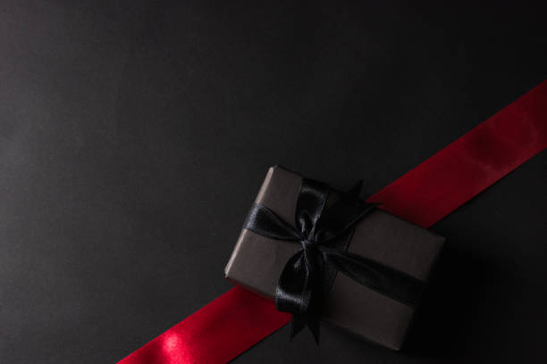 istock gift box wrapped black paper and black bow ribbon press 1343469848