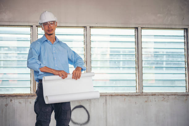 istock Construction engineer man hold blueprint wear blue shirt safety white hard hat at construction site industry labor worker. Architecture man engineer civil worker look at blueprint real estate concept 1343470867