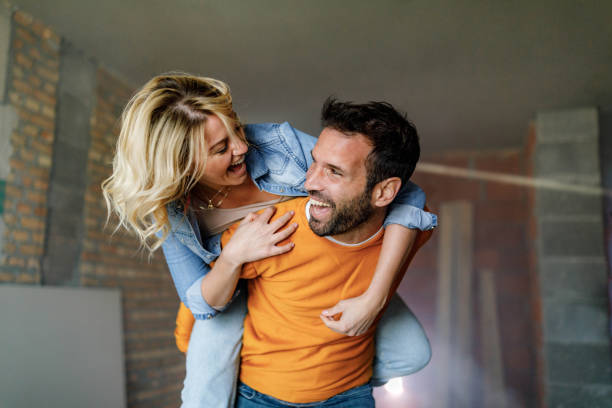 istock Carefree couple having fun while piggybacking at construction site. 1343471031