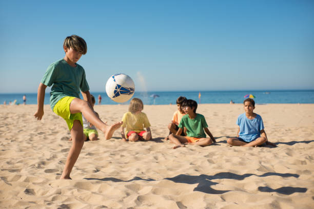 istock Concentrated boy playing with ball on beach 1343471041