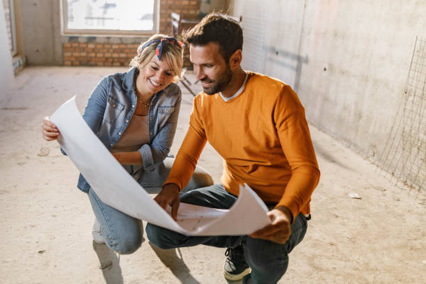 istock Happy couple analyzing plans at their renovating apartment. 1343471190