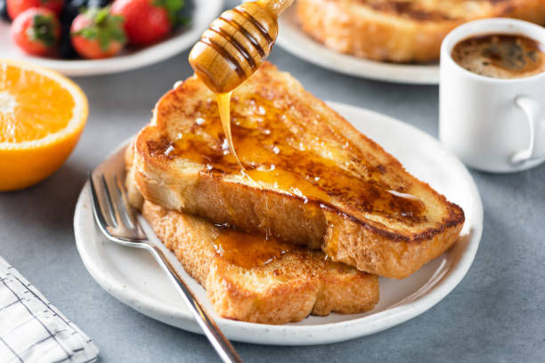 pouring honey on french toast - french toast breakfast food sweet food imagens e fotografias de stock