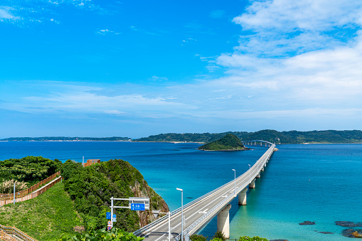 Tsunoshima Bridge in Yamaguchi Prefecture, surrounded by a clear sky and a beautiful sea.