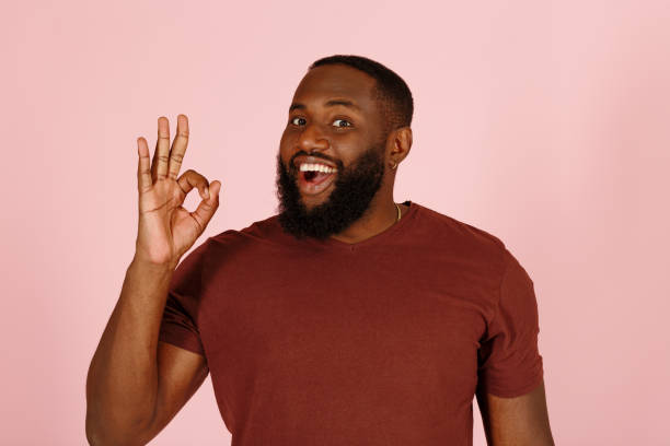 istock Joyful black guy model shows OK gesture standing on pink 1343478740