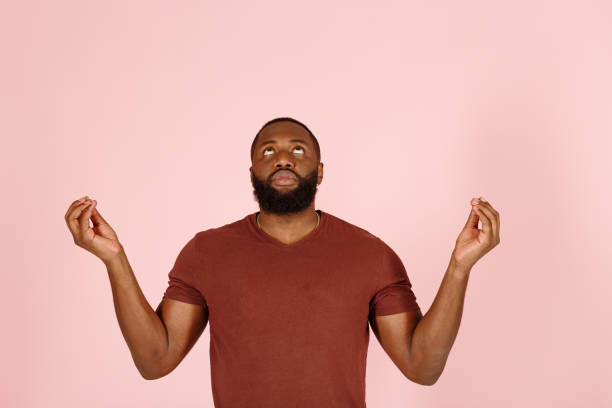 attore afroamericano con la barba medita sul rosa - rolling eyes foto e immagini stock