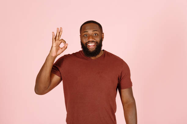 istock Joyful black guy model shows OK gesture standing on pink 1343478801