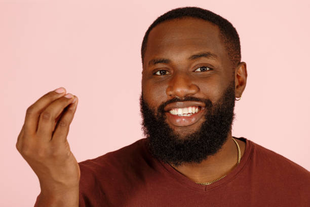 istock Pleasured black man does Italian gesture Tasty on pink 1343478864