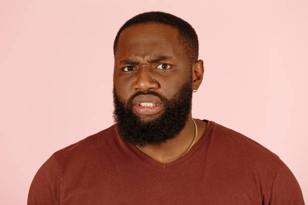 istock Handsome African-American man looks with disgust on pink 1343478877