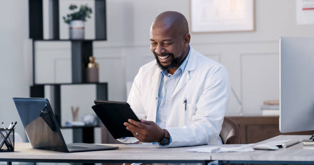 Shot of a male doctor using his digital tablet in his office stock photo