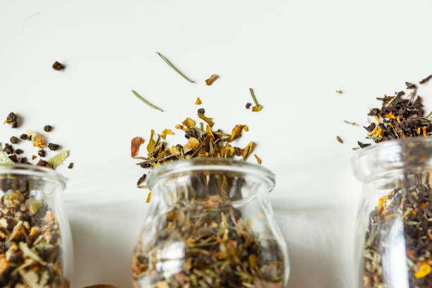 istock Glass jars with dry tea leaves close up on white table 1343482030