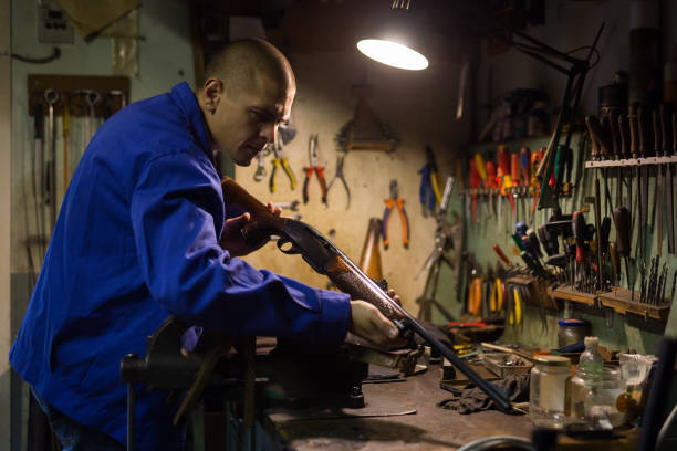 istock Gunsmith performing checkout of single-barrelled shotgun in weapons workshop 1343482449