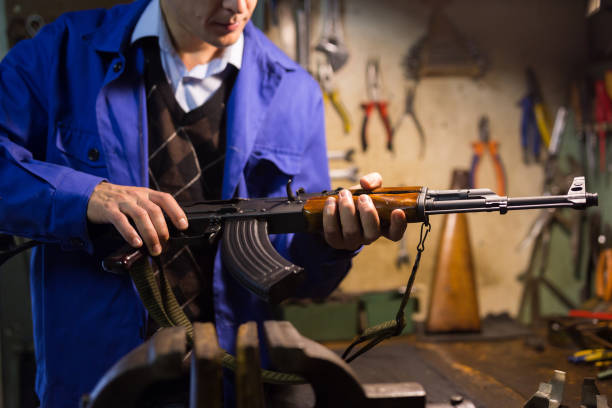 istock Kalashnikov assault rifle in hands of gunsmith in weapons workshop 1343482452