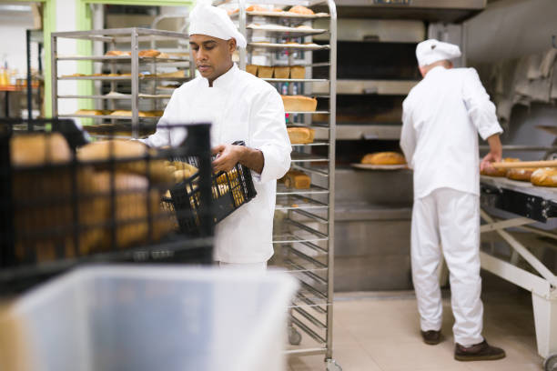 istock Male baker holding crate with baked bread 1343482782