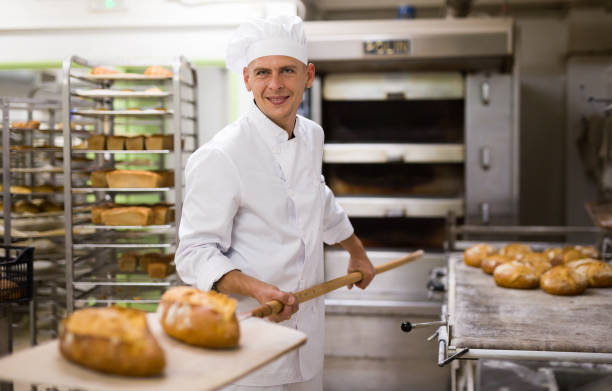 istock Baker taking out from oven baked bread 1343482783