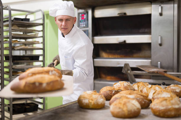 istock man in chefs uniform with bread on shovel in bakehouse 1343482784