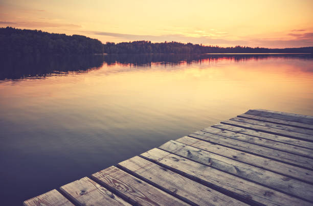 istock Sunset over still lake with a wooden pier. 1343484458