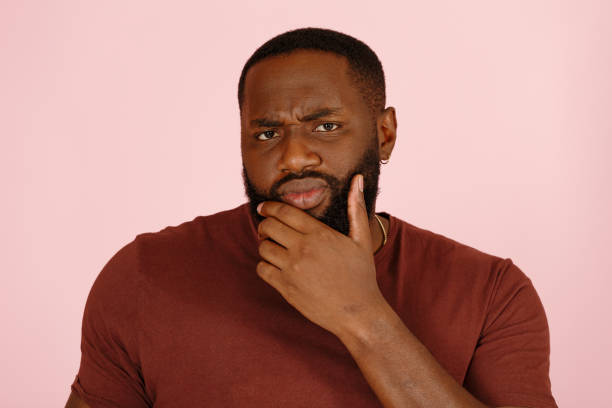 istock Skeptical African-American man thinks posing on pink 1343486365