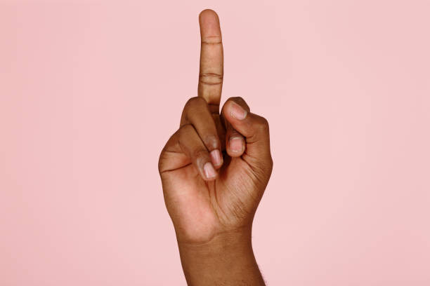 istock African-American man shows middle finger, offensive gesture on pink 1343486841