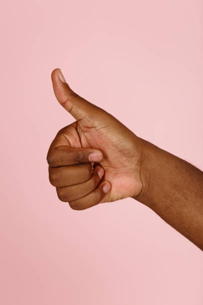 istock African-American man shows thumb-up gesture cheering up on pink 1343486875