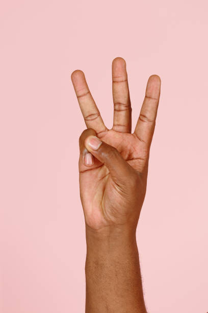 istock African-American man shows three fingers gesture on pink 1343486924